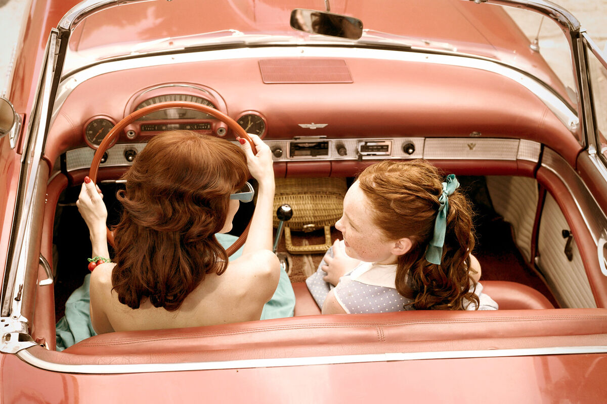 Mother and daughter riding in vintage car