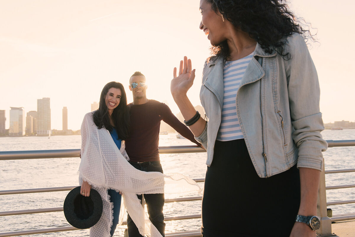 Female friend waving goodbye to an adult couple