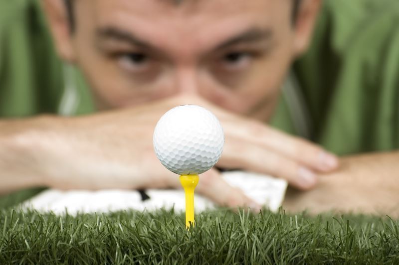 golfer looking at a ball on a tee