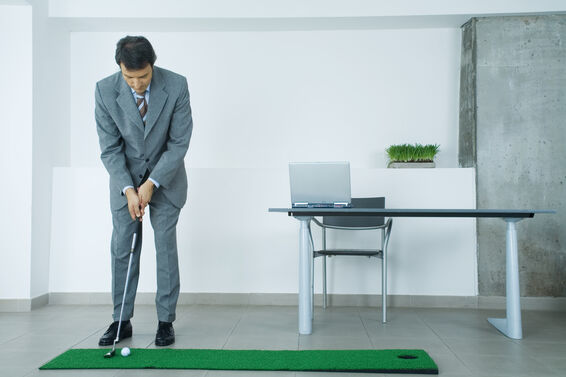 Man practices putting in office