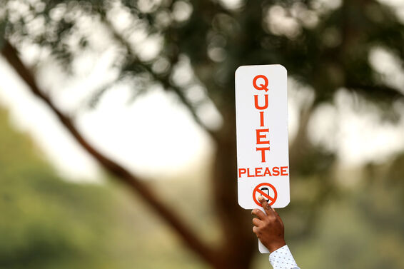 Sign that reads "Quiet Please" at a golf tournament