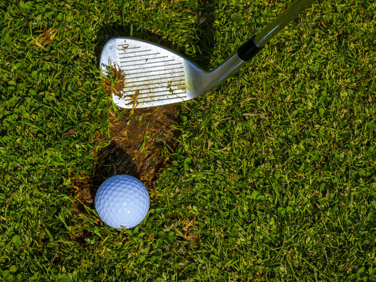 Golf ball sitting in a divot in the fairway