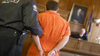 man in hand cuffs in court