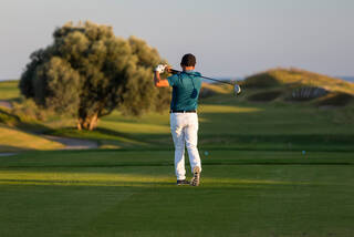 Man hitting driver on a golf course