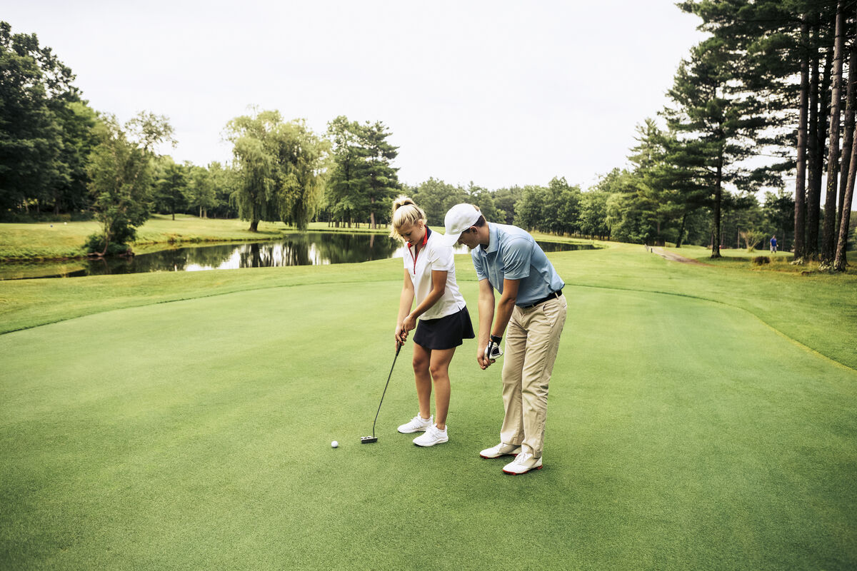 Woman learning how to play golf