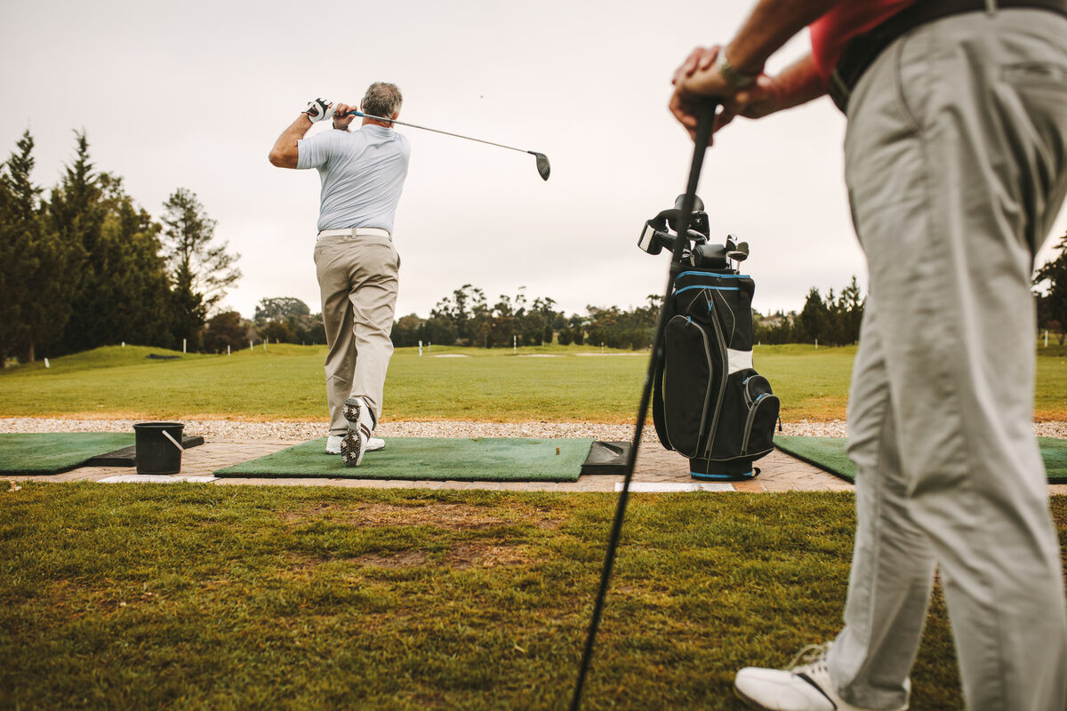 Man practicing his golf swing on the driving range