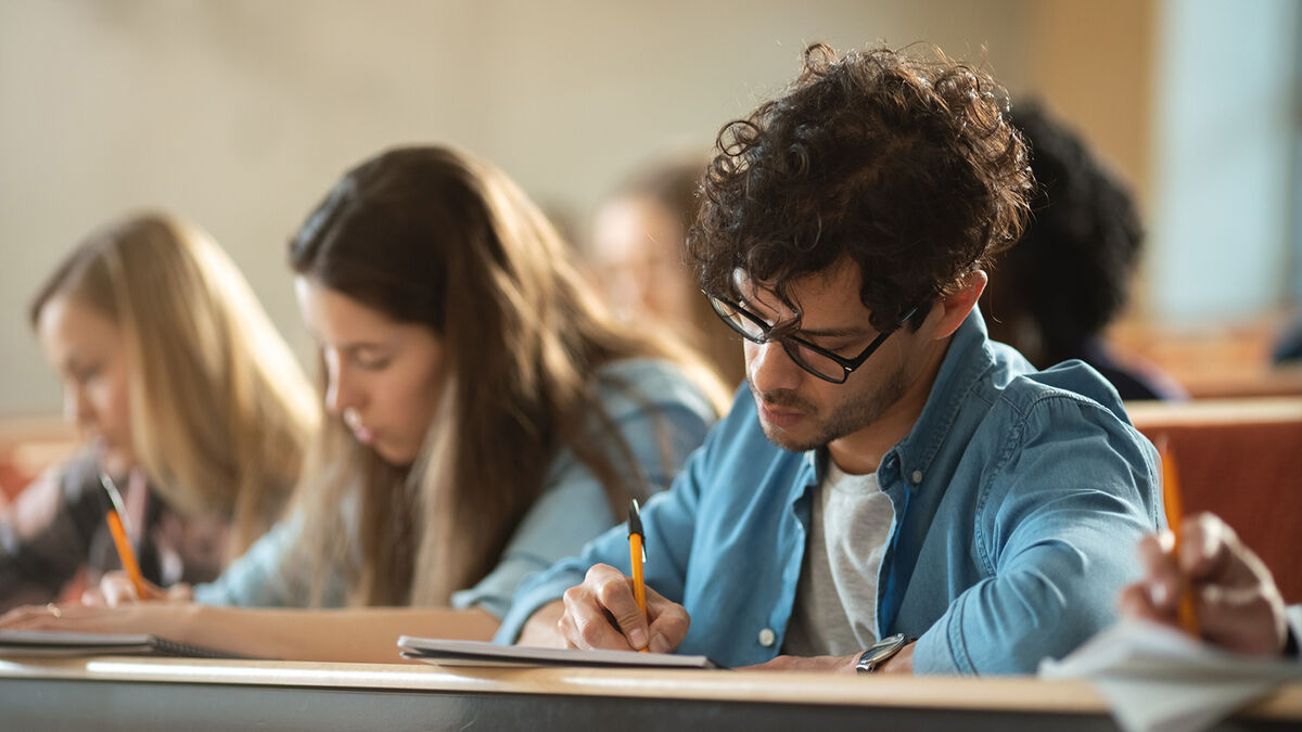 College student taking notes in class