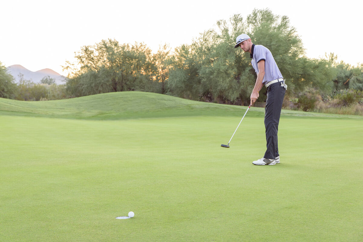 Golfer practicing putting distance control