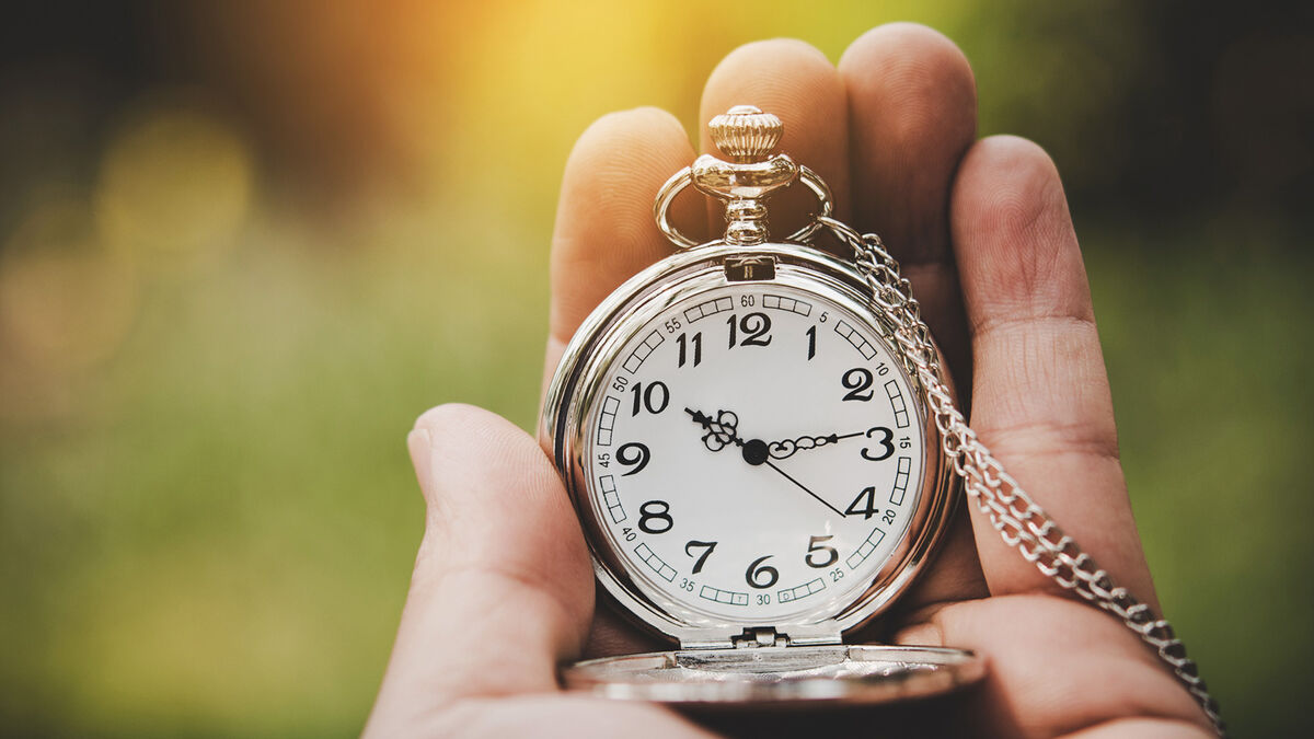 Hand holding a pocket watch