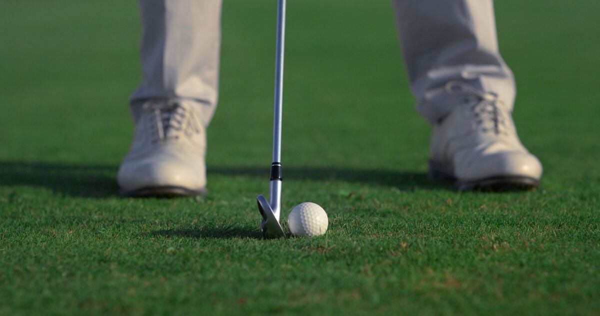 Golfer at address with the club behind the ball