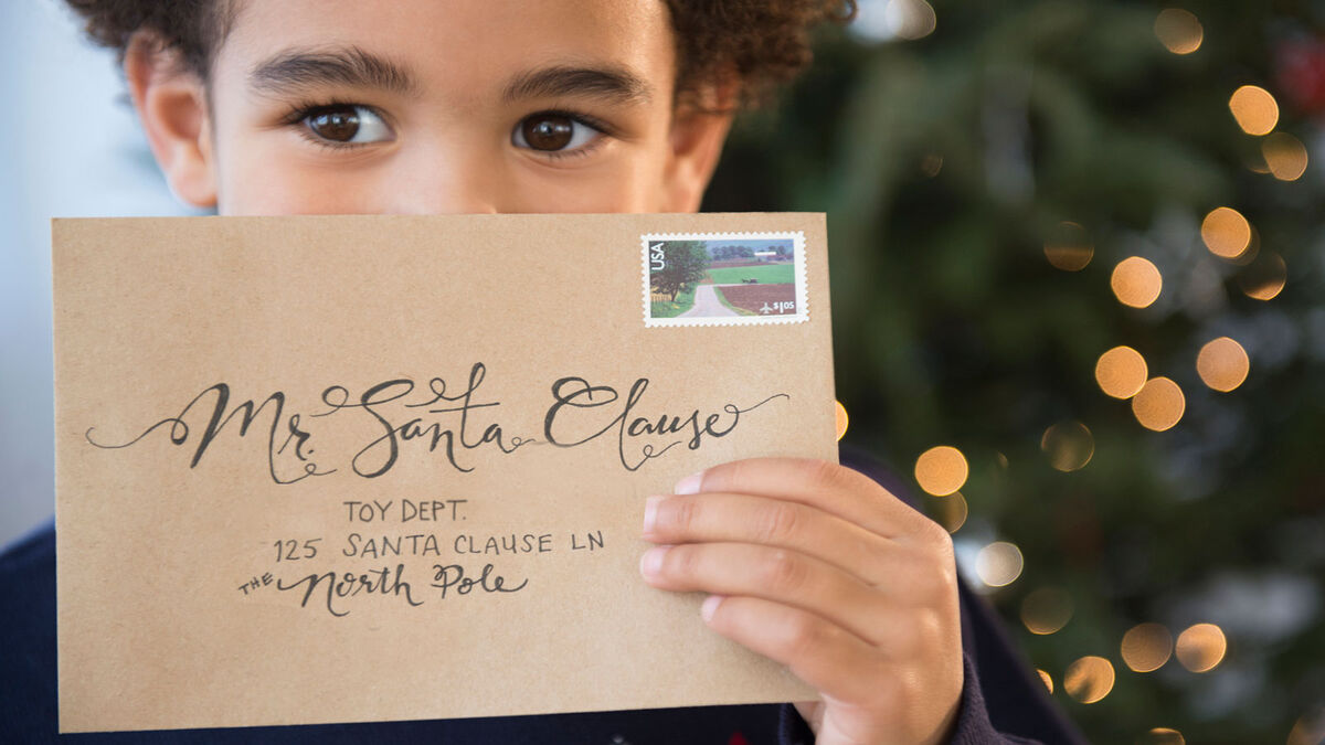 Boy holding letter addressed to Santa