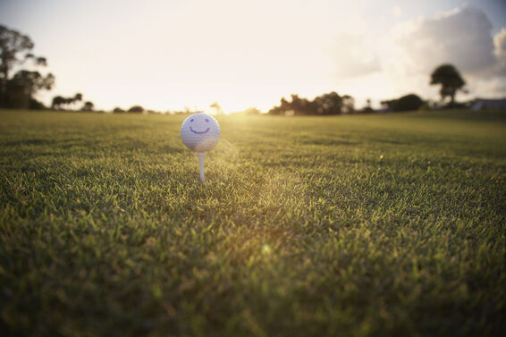 Golf ball with a smile drawn on it