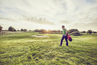 Bogey golfer walking the course at sunset