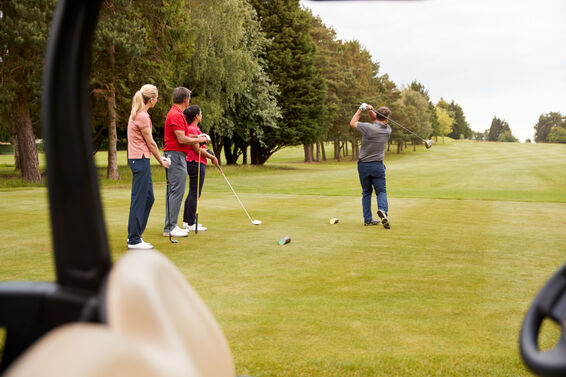 Four golfers playing golf