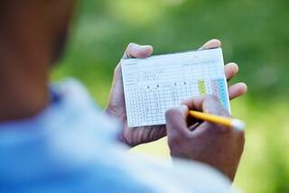 Golfer writing down a score on the scorecard