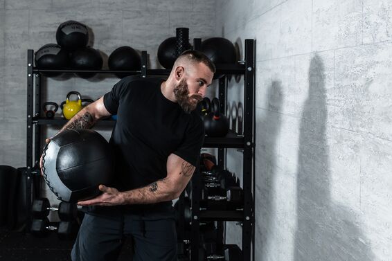 Man building rotational power through medicine ball side throws