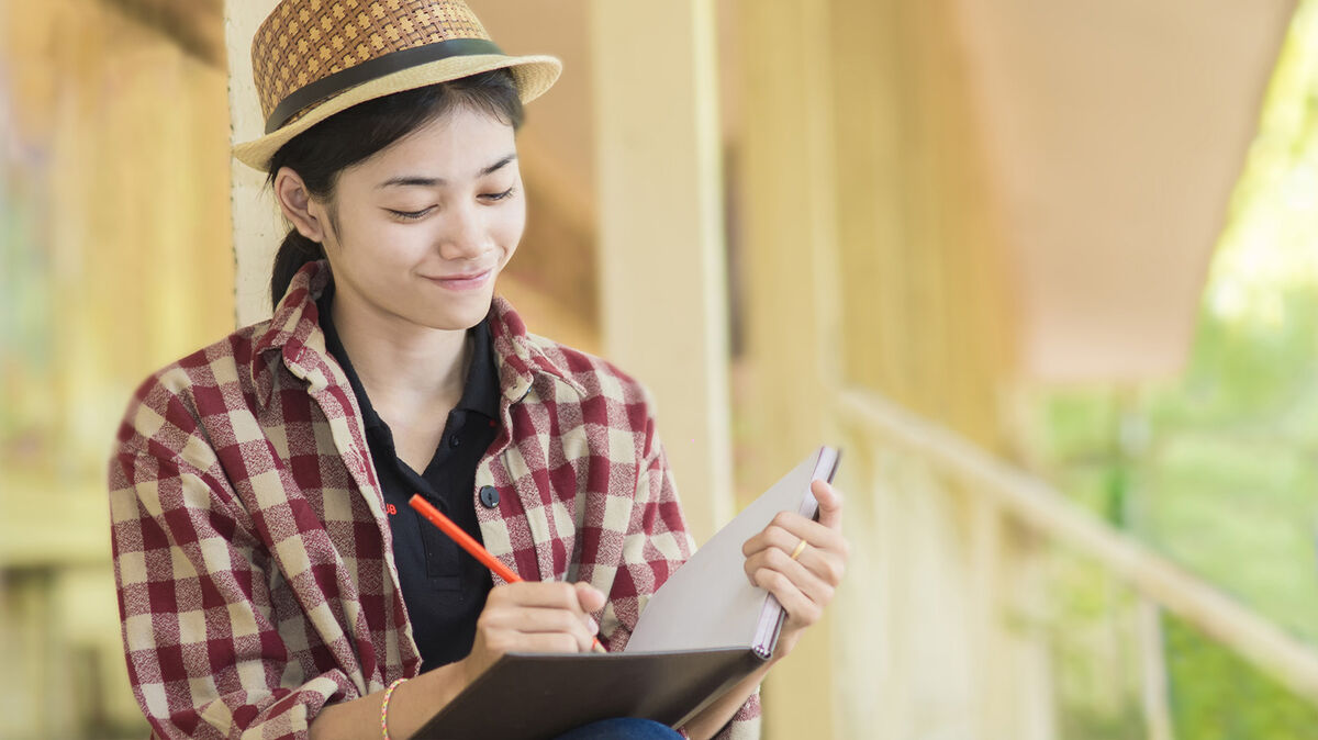 woman doing creative writing in book