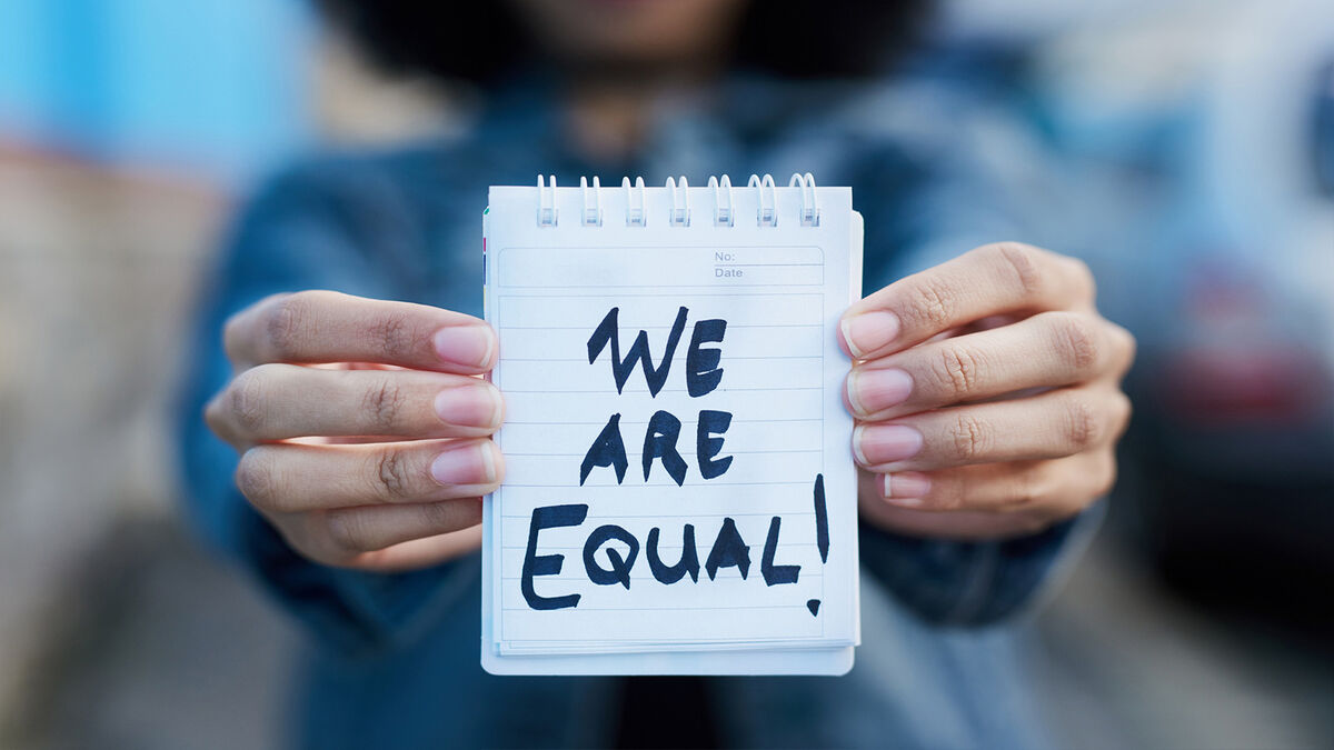 woman holding we are equal sign