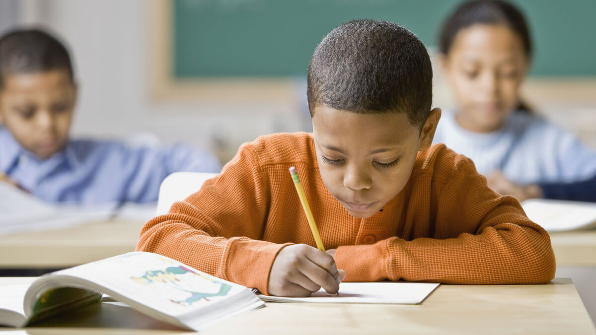 Boy practicing adverb worksheet at school