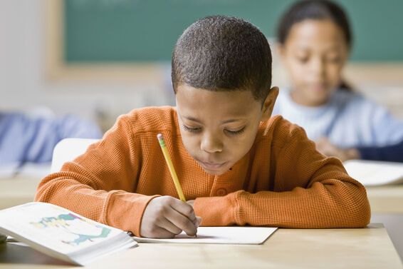 Boy practicing adverb worksheet at school