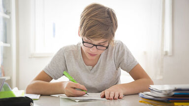 Student doing adjective worksheet for homework Student doing adjective worksheet for homework