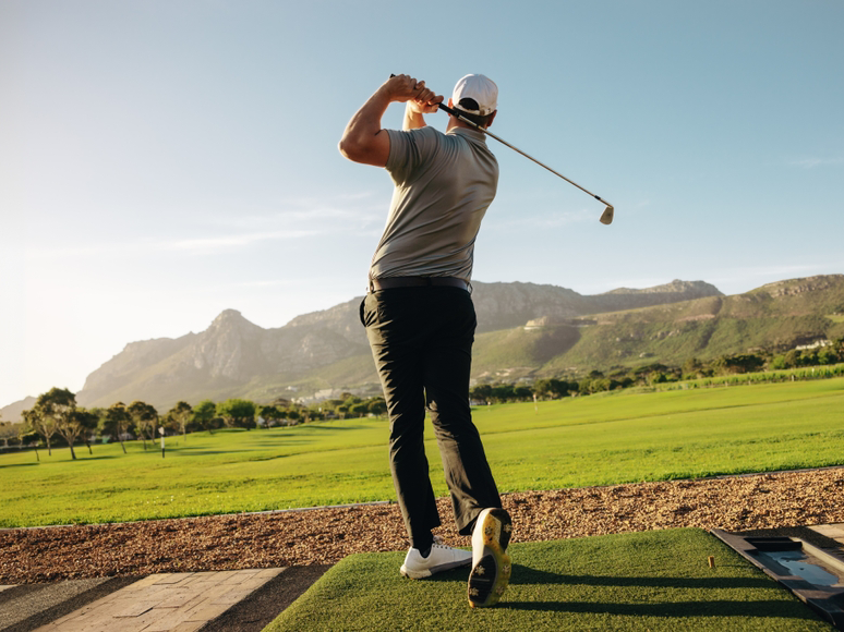 Golfer practicing iron play at the driving range