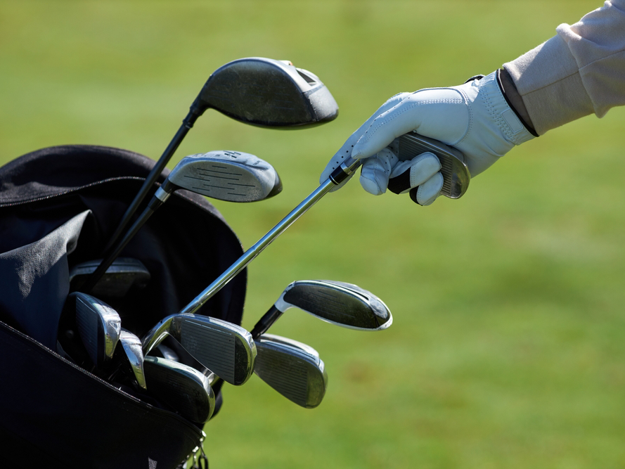 Golfer reaching for an iron