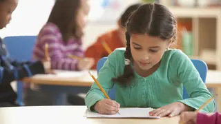 First grade school girl working on educational worksheet