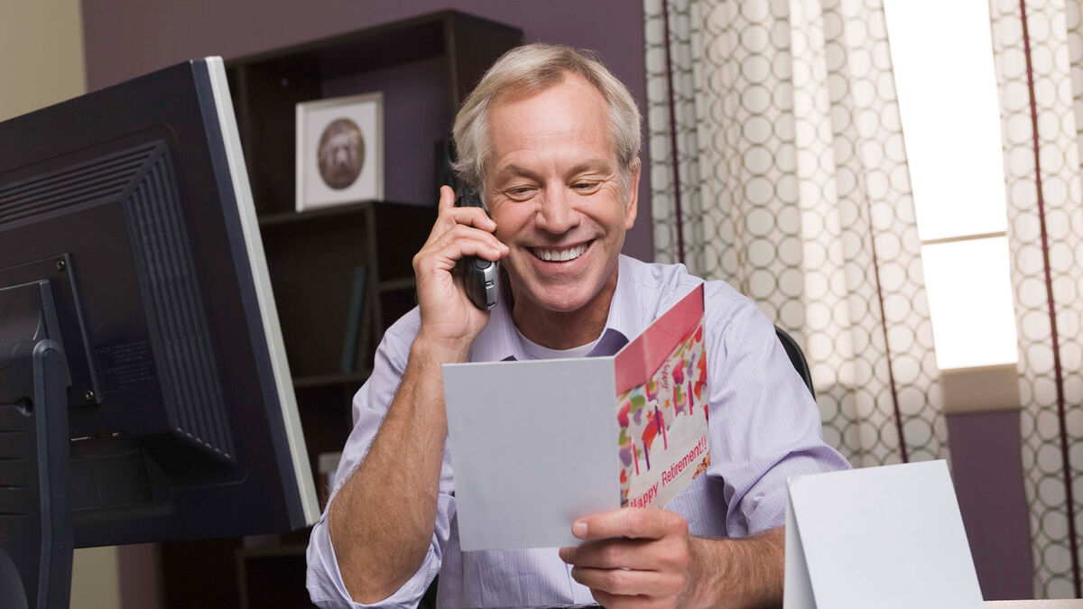 man reading funny retirement card in office