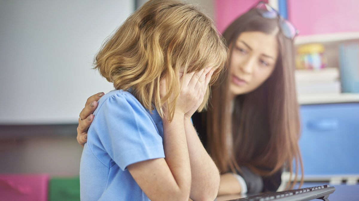 Emotional student consoled by empathetic teacher