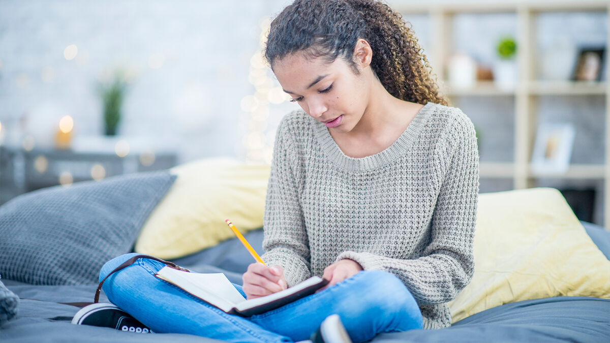 Teen girl writing in journal