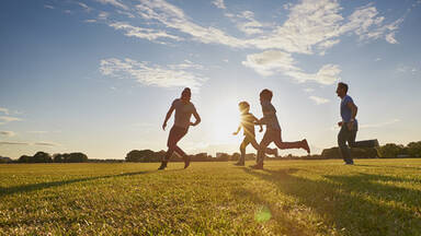 Family running in sunny meadow Family running in sunny meadow