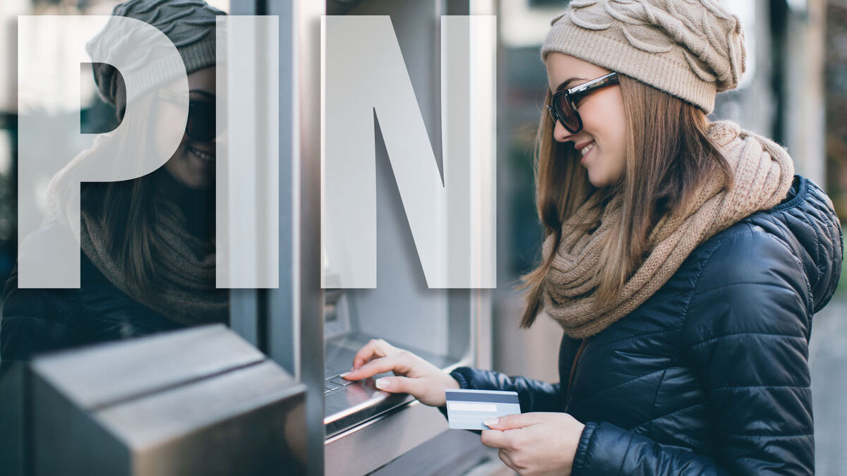 Woman entering PIN at an ATM