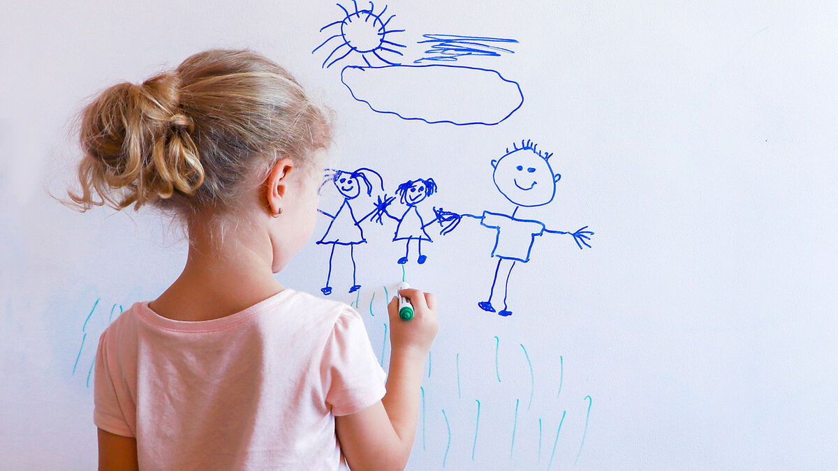 Girl drawing pictionary word on whiteboard