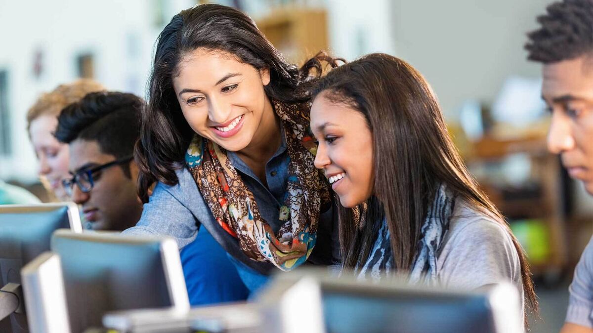 teacher helping student with essay writing assignment