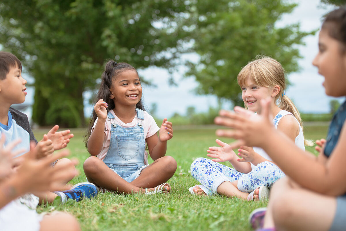 Group of children are clapping and singing together.