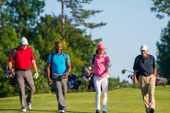 Four golfers walking on course