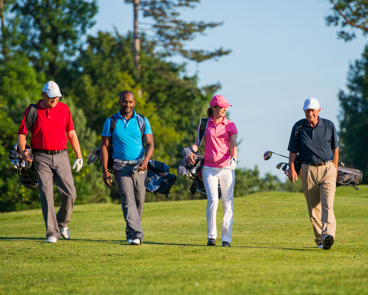 Four golfers walking on course