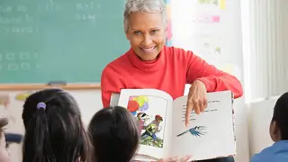 teacher reading picture story book to class