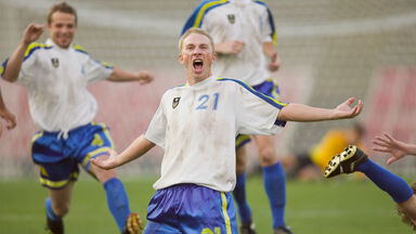 soccer players celebrating score goal