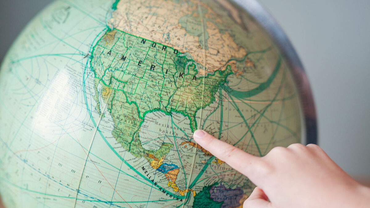 child pointing to Florida on a globe