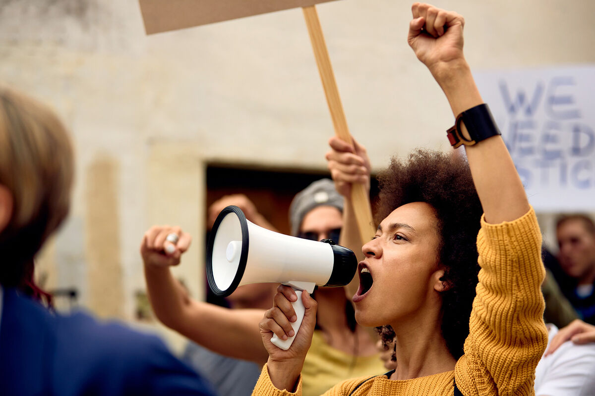 Young Black woman shouting through megaphone