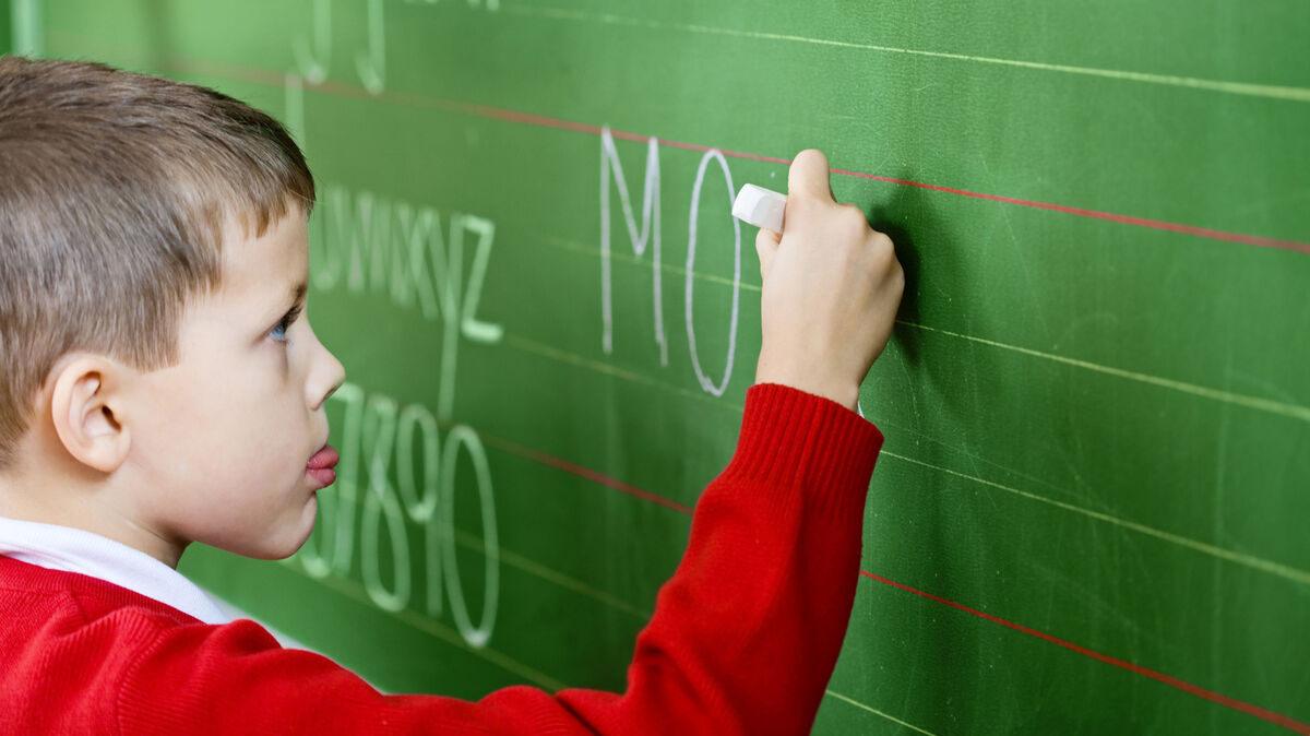 boy writing chalkboard assess vocabulary