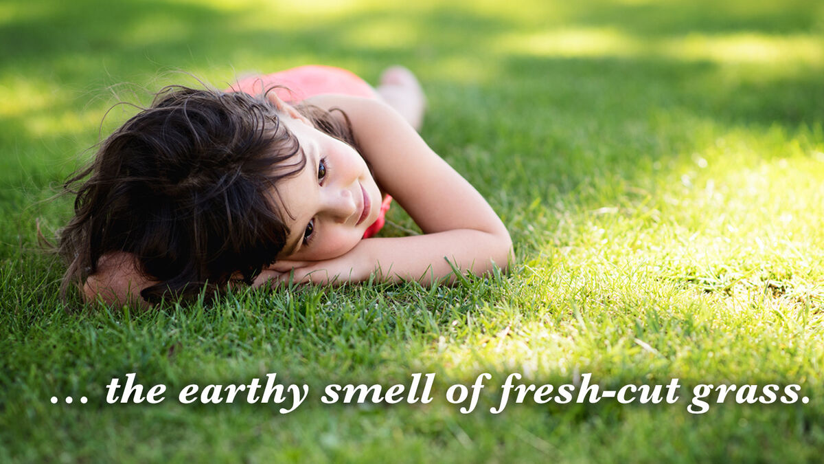 girl smelling fresh-cut grass
