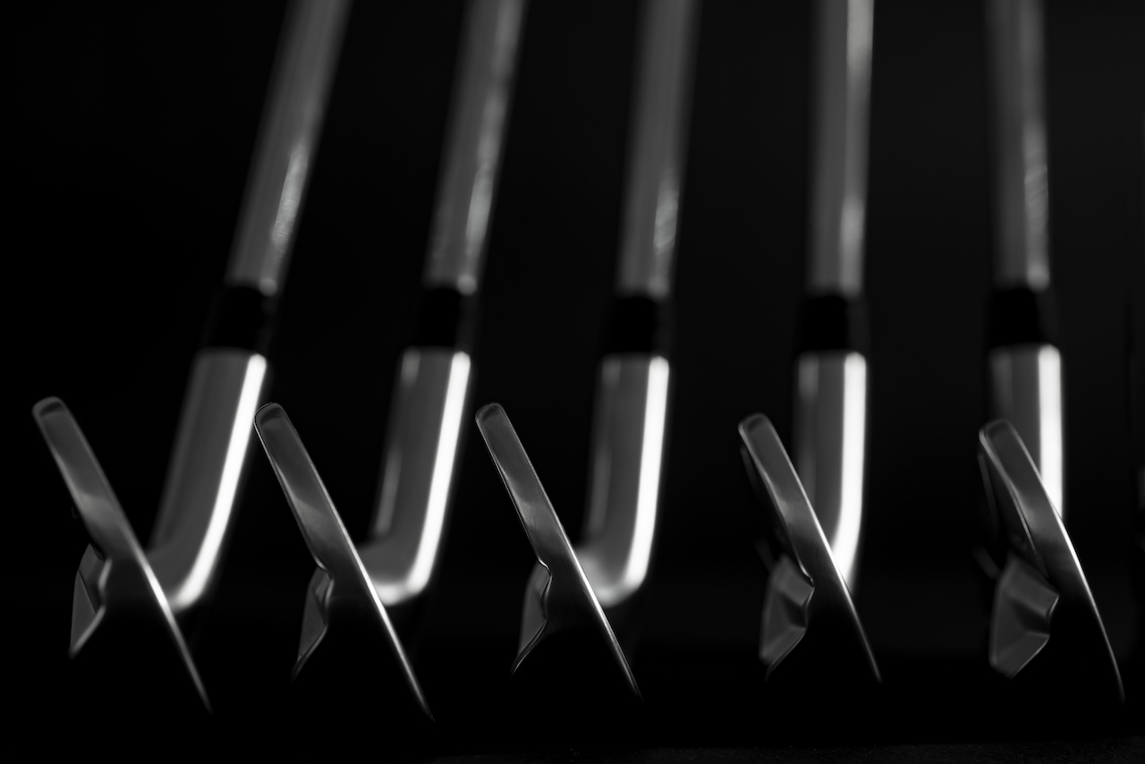 Sleek golf clubs with black background