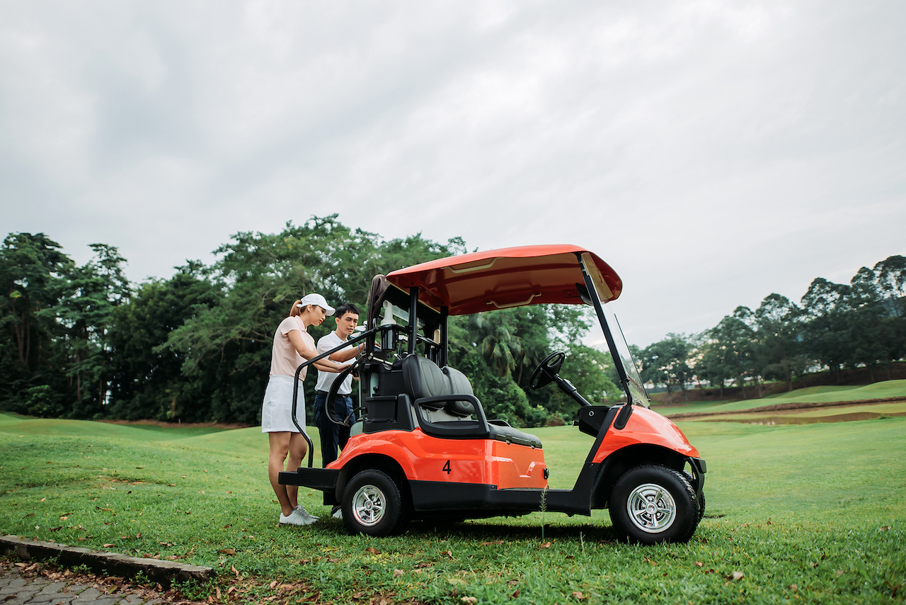 Couple placing bags on golf cart