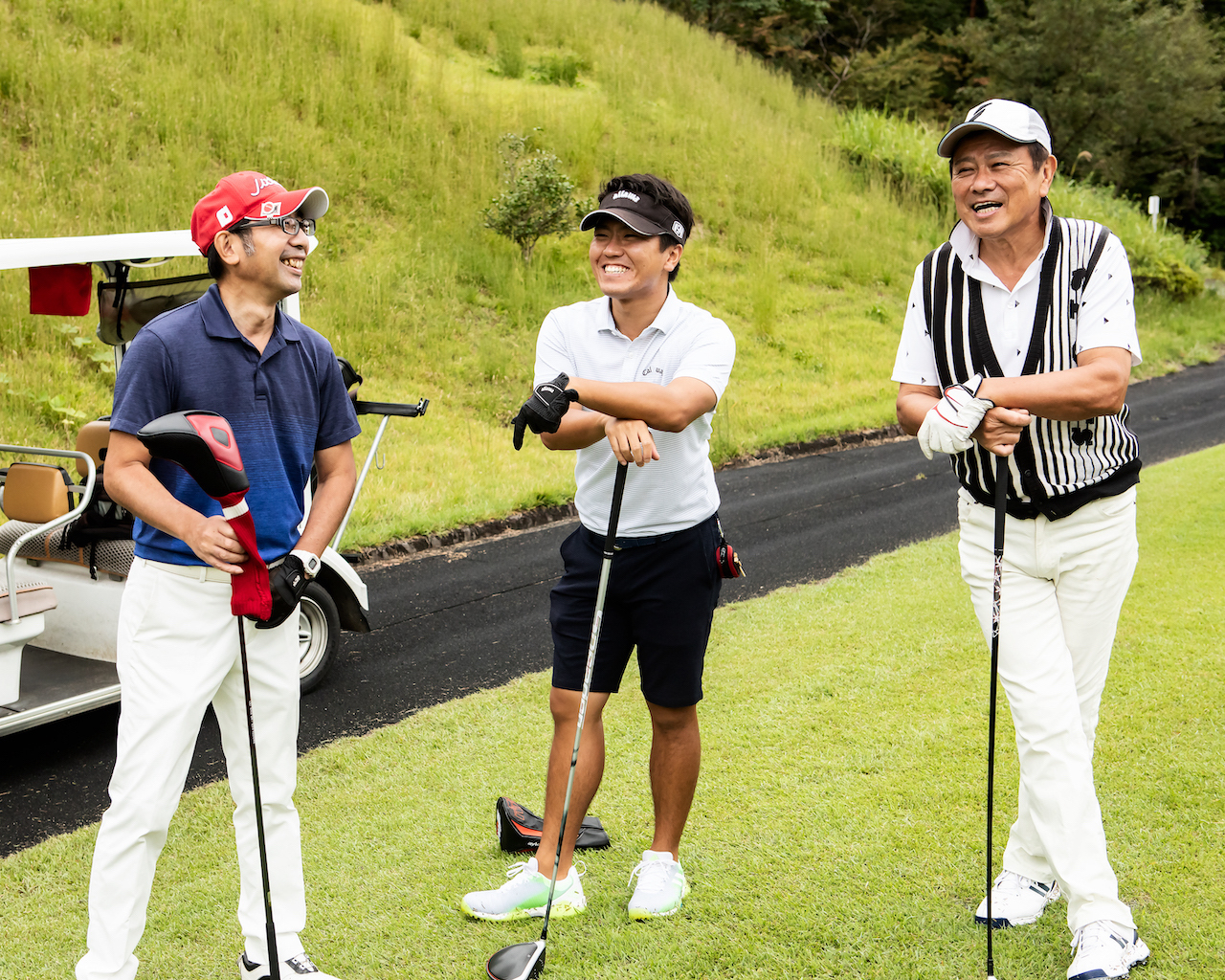 Three golfers smiling at tee box
