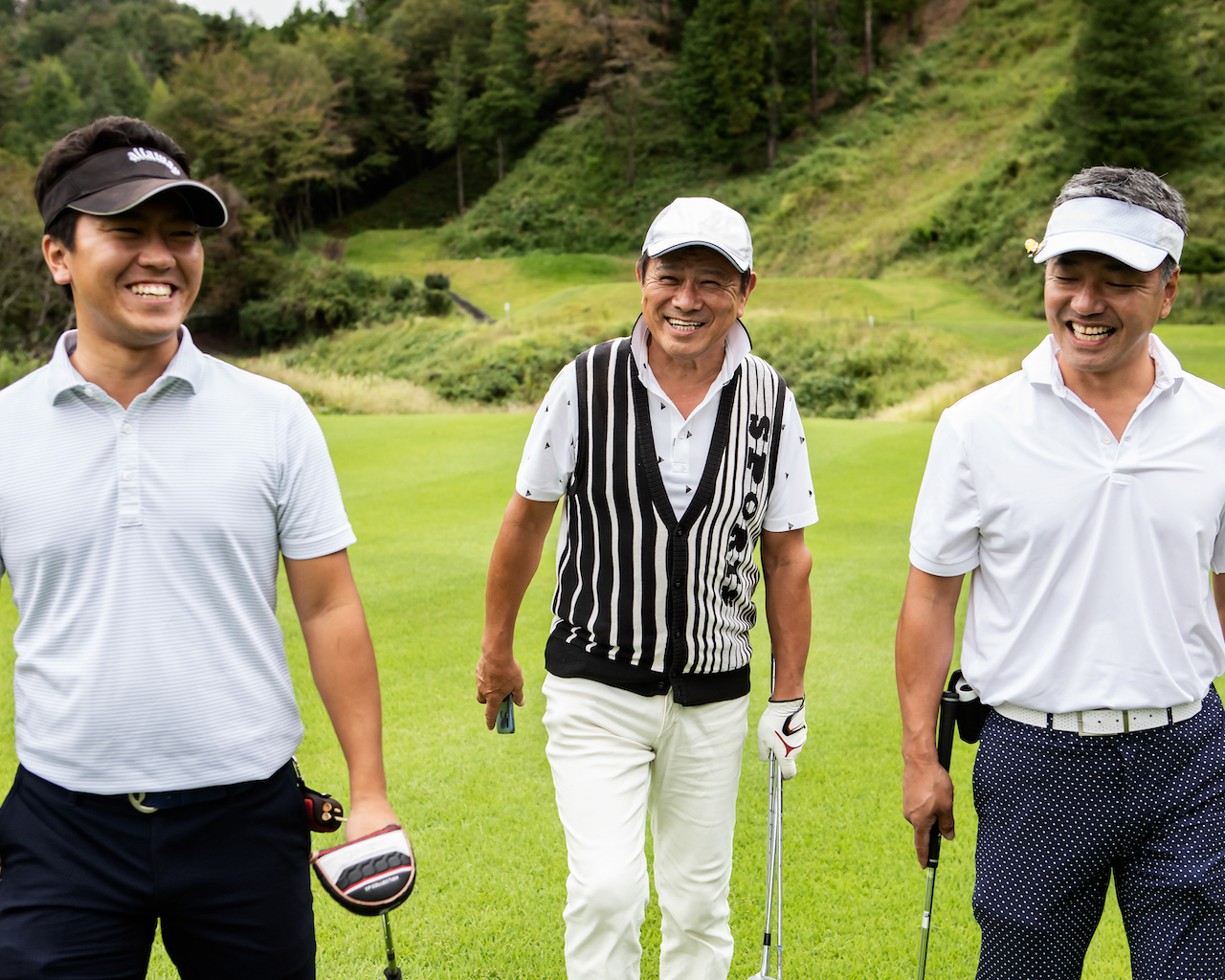 Three golfers smiling on course