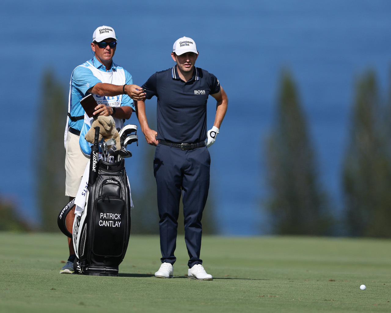 Patrick Cantlay reads putt with caddy