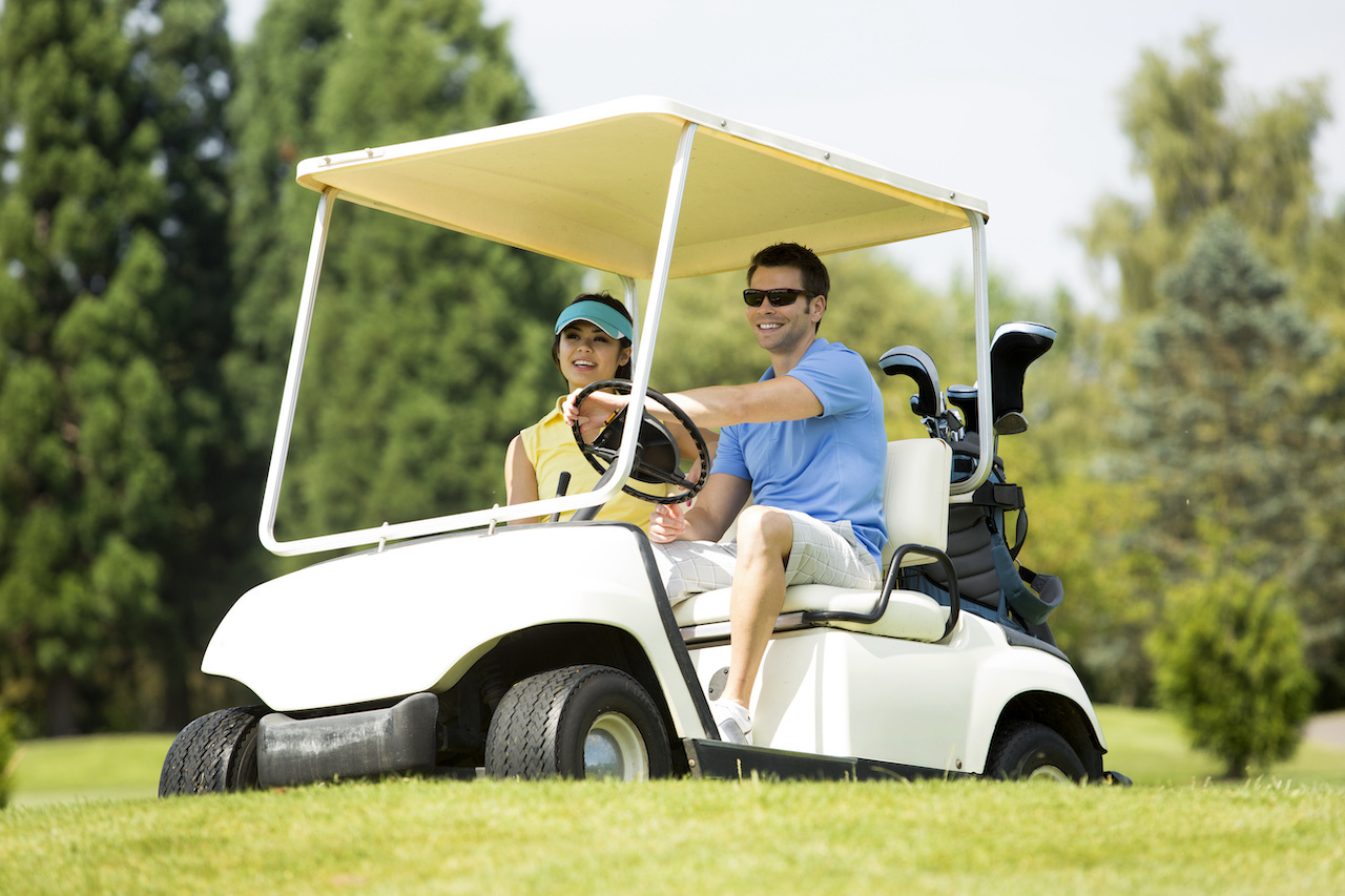two golfers driving golf cart